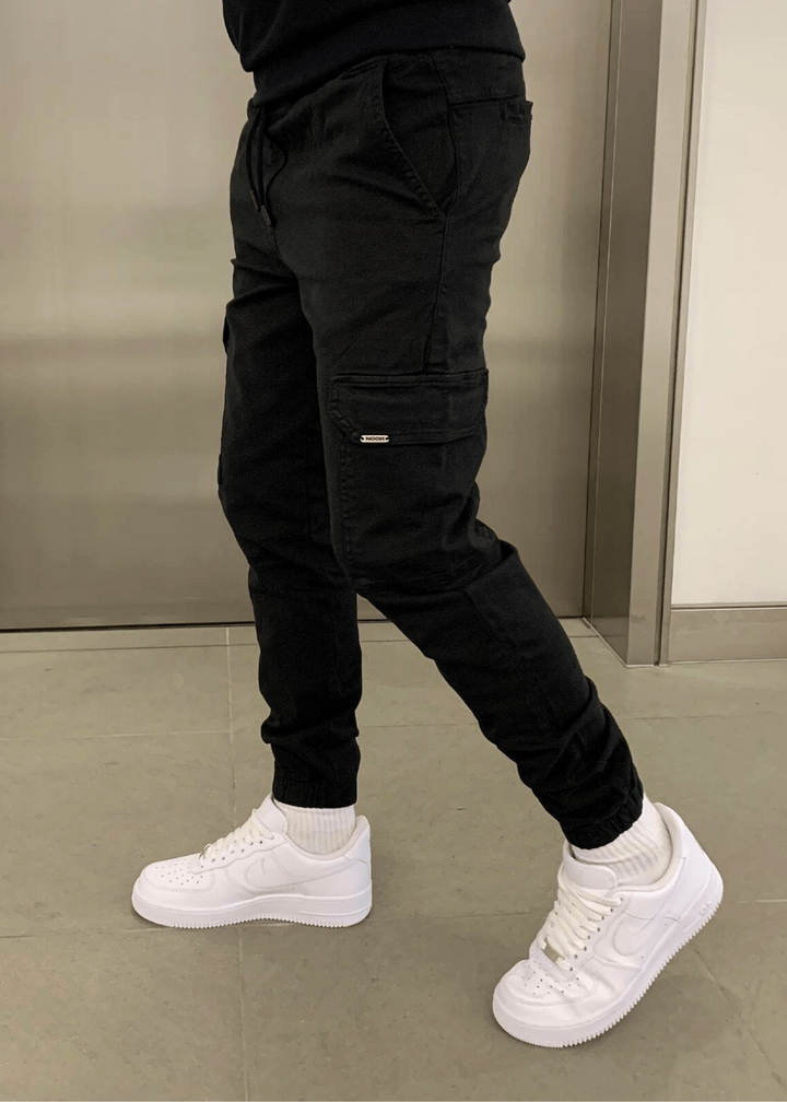 Model präsentiert bequeme Herren Cargo-Jogginghose in zeitloser Farbe, vielseitig für jeden Look.