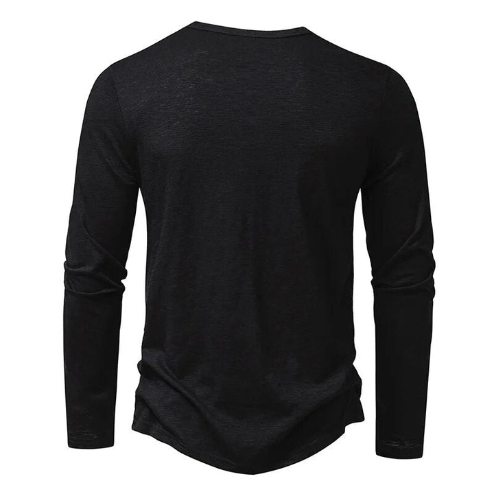 Mann trägt ein elegantes Herren Henley Langarmshirt mit schmaler Passform und modernem Stil.
