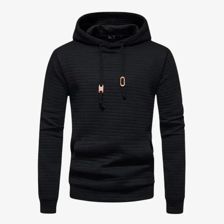 Junger Mann trägt trendigen Karomuster Hoodie. Bequemer Herren Kapuzenpullover für Freizeit und urbanen Lifestyle.