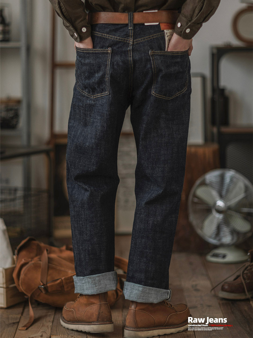 Mann trägt modische Indigo Herren Jeans mit geradem Schnitt für einen lässigen und zeitlosen Look.