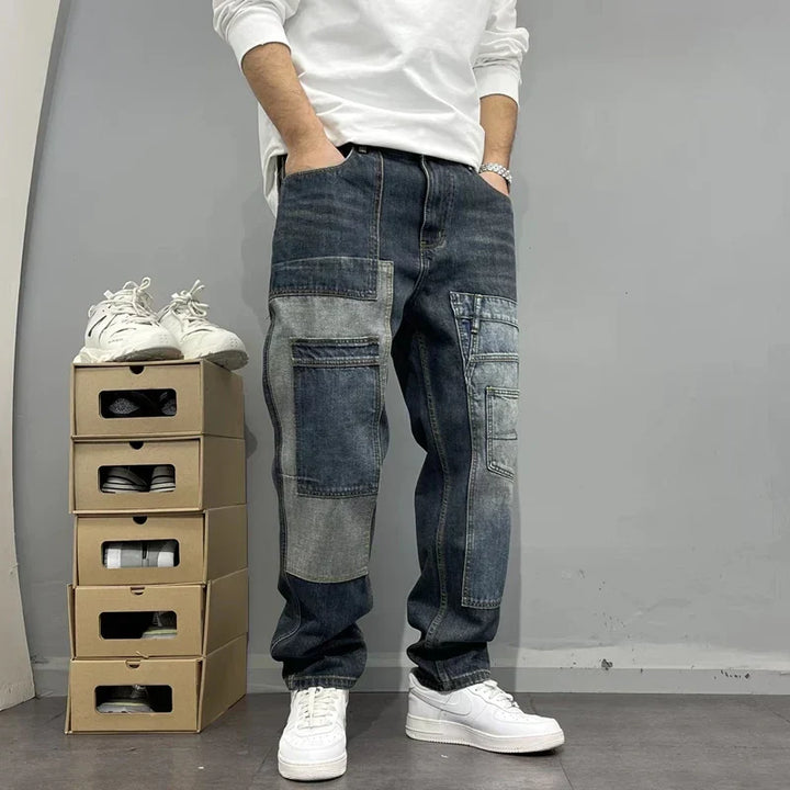 Detailansicht Herren Patchwork Jeans mit markanten Cargo-Taschen. Moderne Männer Streetwear Hose im Urban Look.