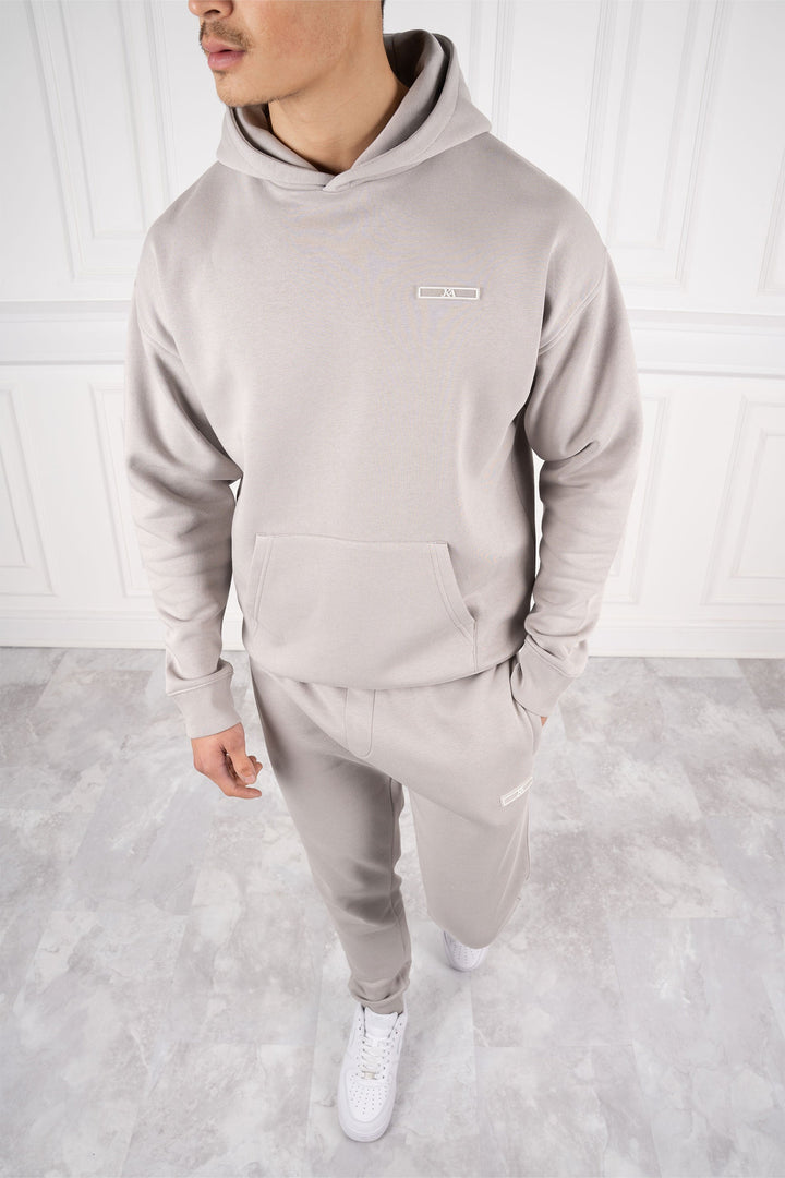 Mann trägt modernen Slim Fit Trainingsanzug mit Kapuze und Hose, ideal für Sport und täglichen Komfort.