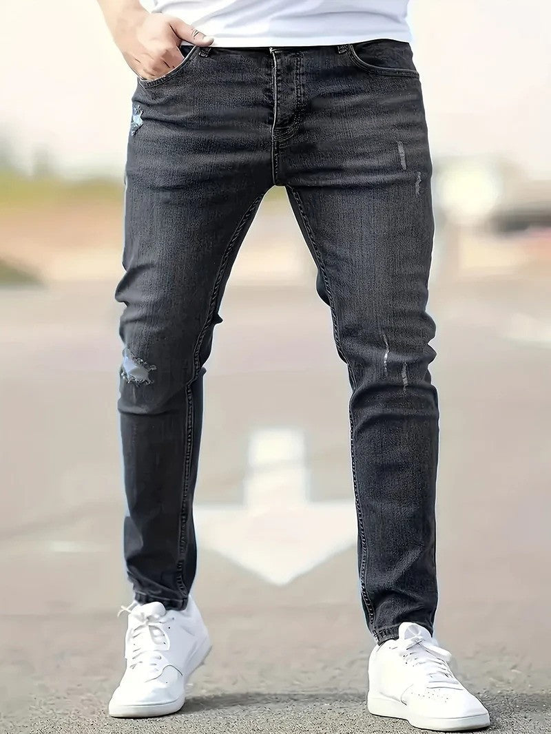 Nahaufnahme der Herren-Stretch-Jeans, Detail des zerrissenen Designs und Stretch-Materials für Komfort.