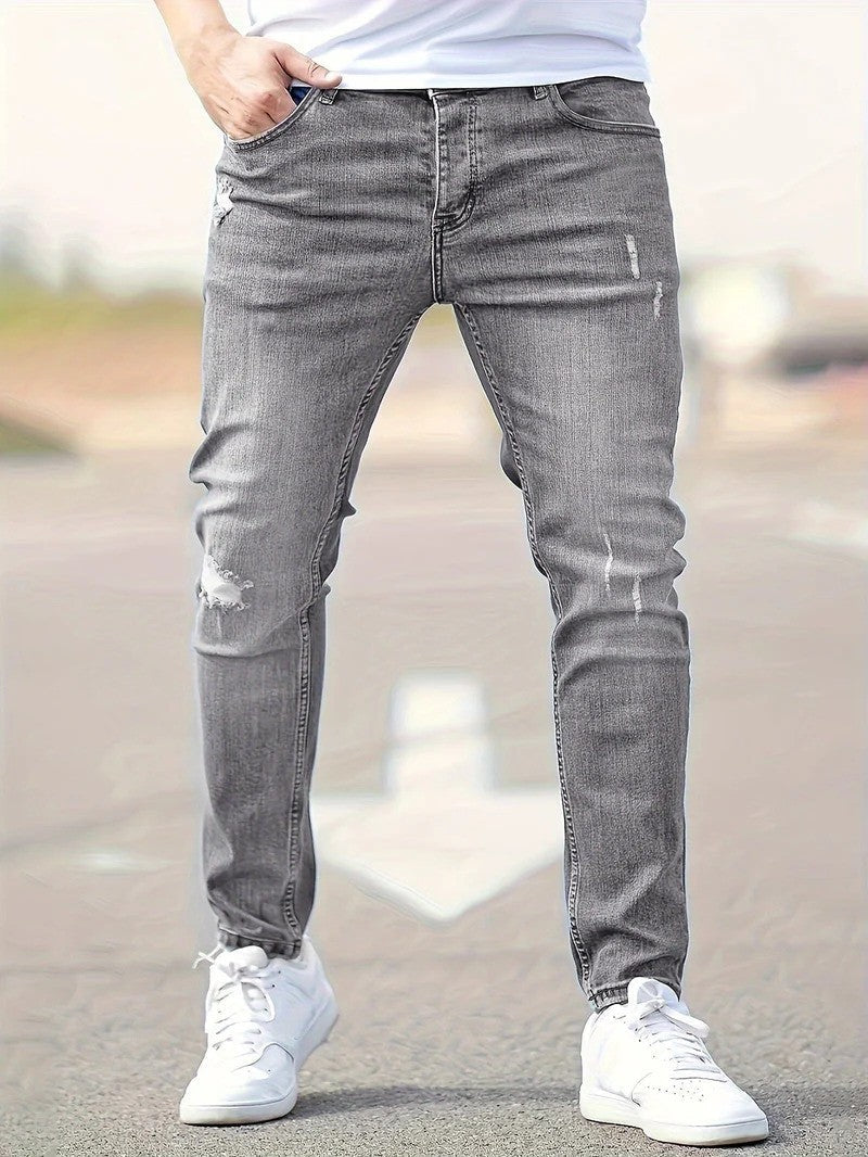 Moderner Mann trägt Slim Fit Stretch-Jeans mit Ripped-Design, ideal für Streetwear und lässigen Urban Style.
