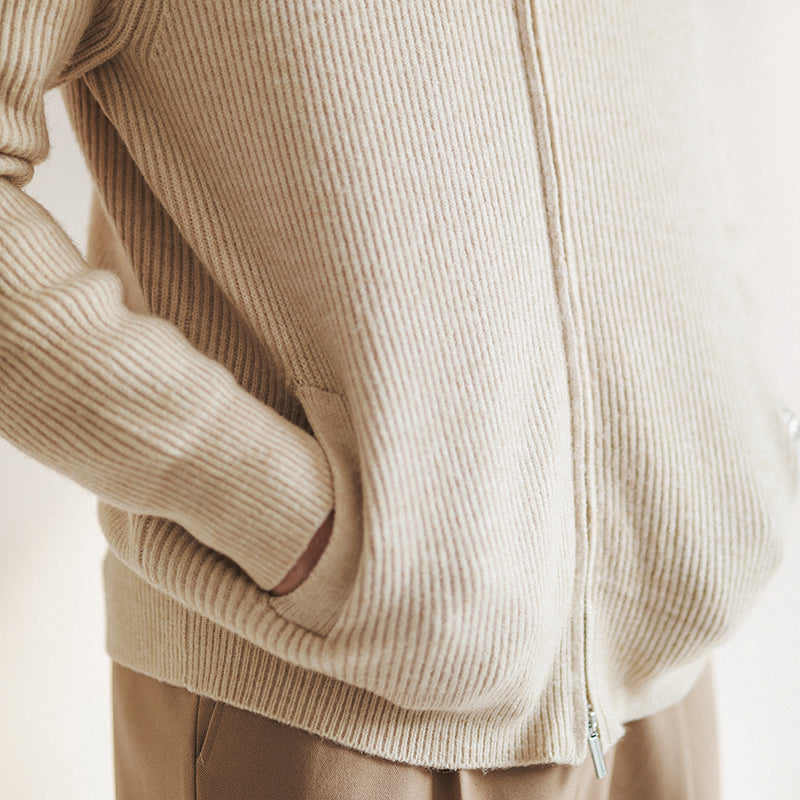 Nahaufnahme des Reißverschlusses am Herren Strickpullover. Die feine Rippstruktur und das weiche Material sind sichtbar.