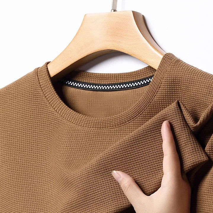 Detailansicht: Atmungsaktives Herren Kurzarm T-Shirt mit markanter Waffelstruktur und Rundhals-Kragen.