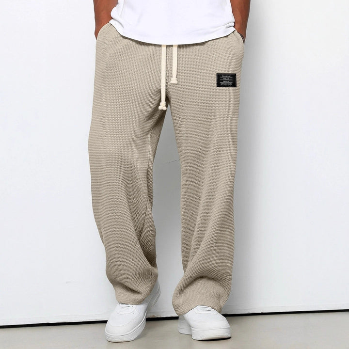 Mann trägt weite Freizeithose Streetwear. Bequeme Herrenhose mit verstellbarem Bund für entspannten Alltagslook.