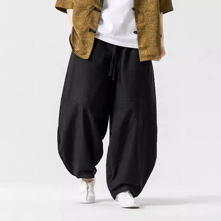 Stilvolle beige Herren-Weithose mit weitem Schnitt, Elastikbund und Ziernähten. Moderne Freizeithose für Männer.