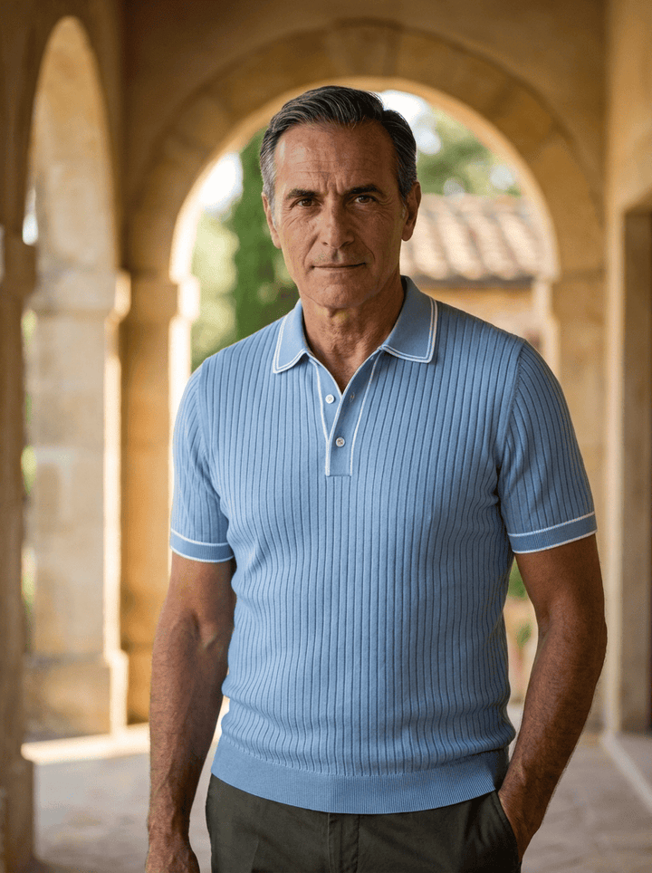 Älterer Mann trägt ein hellblaues, geripptes Herren Hénry Polo-Shirt in einer historischen Arkade