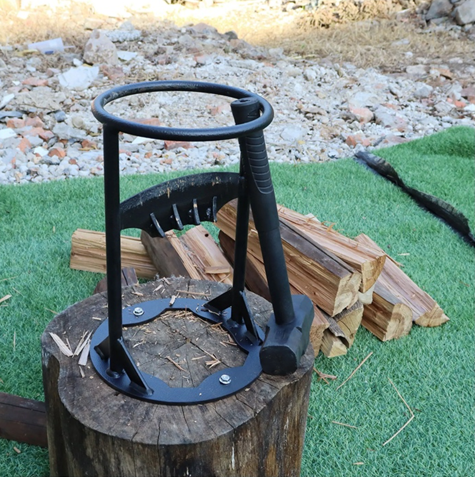 Holzspalter aus Metall auf Baumstumpf, umgeben von Holzscheiten, ideal für Gartenarbeit.