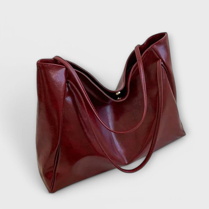 Detail des Henkels der eleganten roten Damen-Handtasche, robuster und bequemer Griff für Tragekomfort.