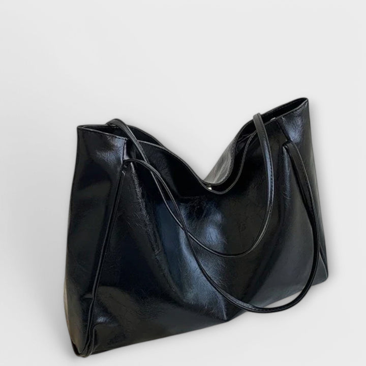 Elegante schwarze Damen-Handtasche als Schultertasche getragen, modisches Accessoire für Stilbewusste.