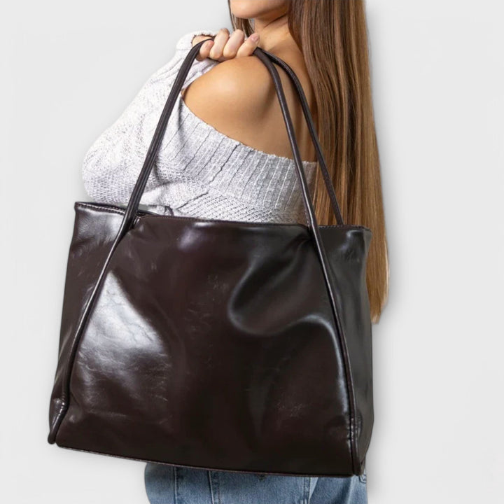 Rückseite der minimalistischen dunkelbraunen Damen-Handtasche, schlichtes Design für zeitlose Eleganz.