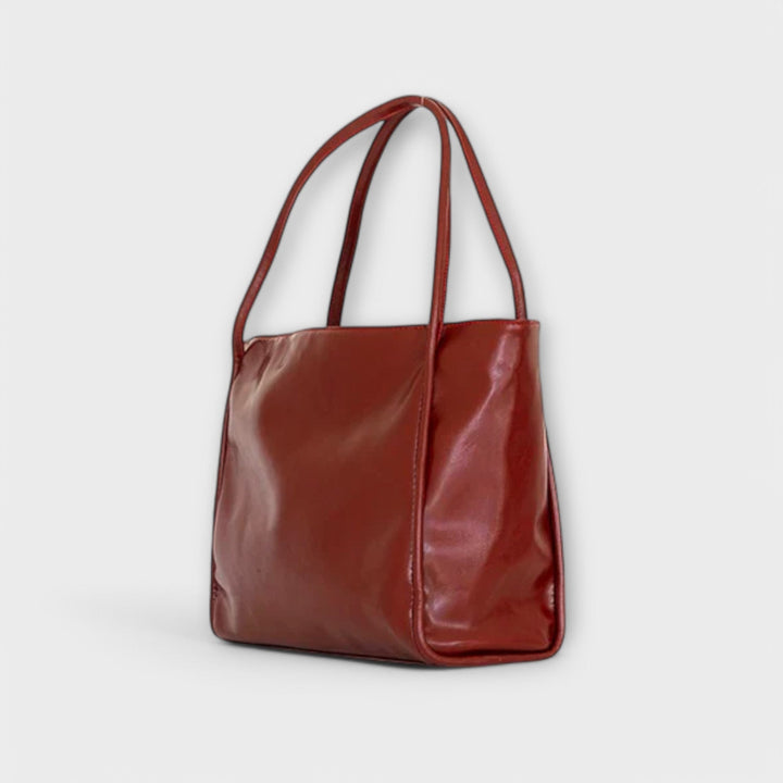 Seitliche Ansicht der roten Damen-Handtasche, schlankes und elegantes Design, vielseitige Schultertasche.