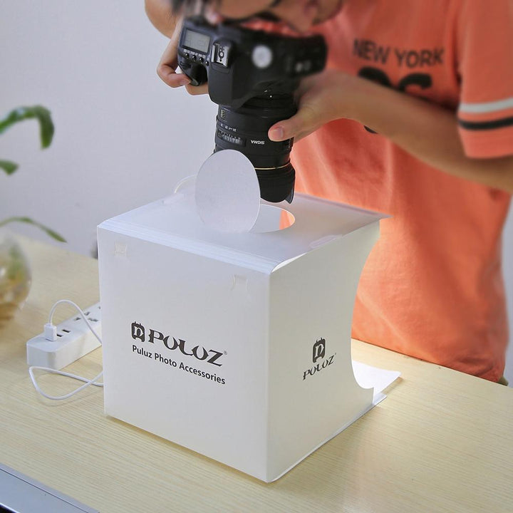 "Kompaktes tragbares Fotostudio mit LED-Licht: Weiße Box, darin hell beleuchtet, ideal für Produktfotografie Gadgets."