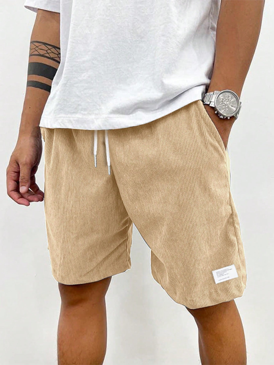 Mann trägt lässige Herren Sommer Shorts in Beige, perfekt kombiniert für einen entspannten Sommerstil.