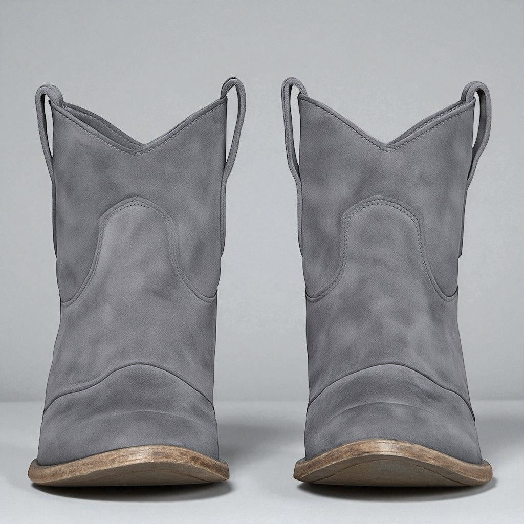 Detailaufnahme des stabilen Blockabsatzes an eleganten Damen-Western-Stiefeletten.