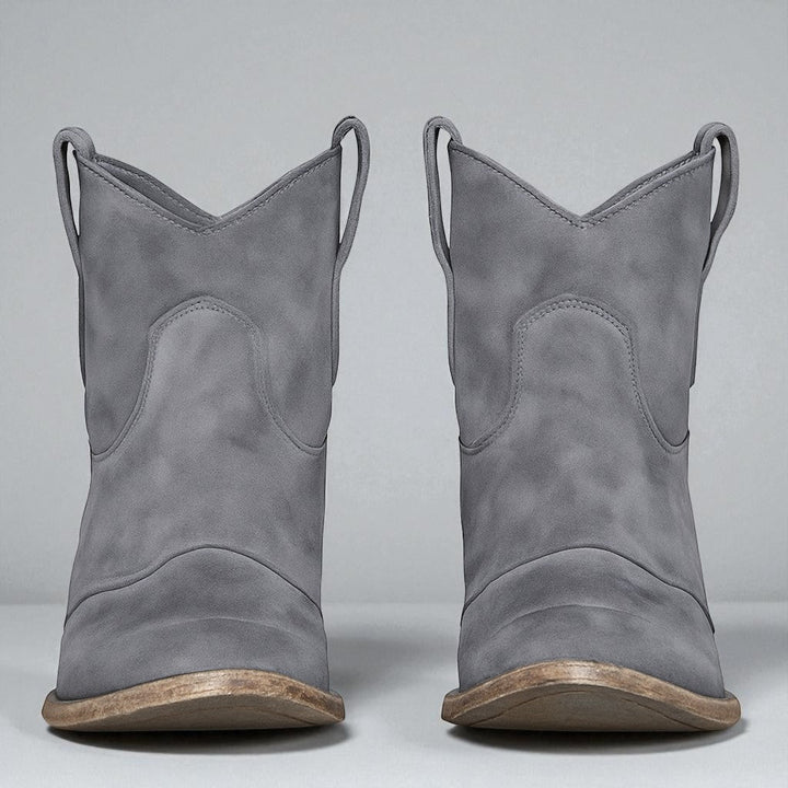 Detailaufnahme des stabilen Blockabsatzes an eleganten Damen-Western-Stiefeletten.