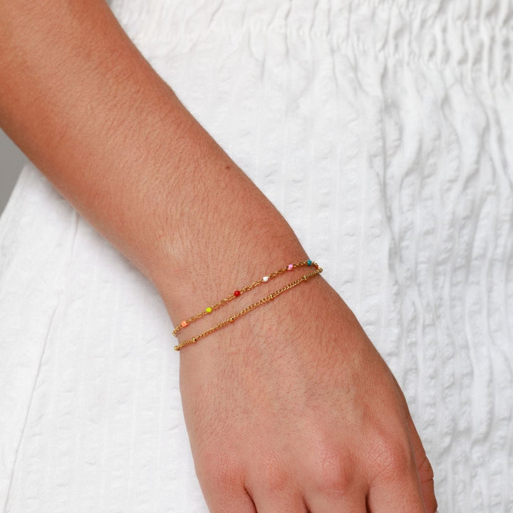 Damen Armband bunt Gold am Handgelenk vor weißem Hintergrund