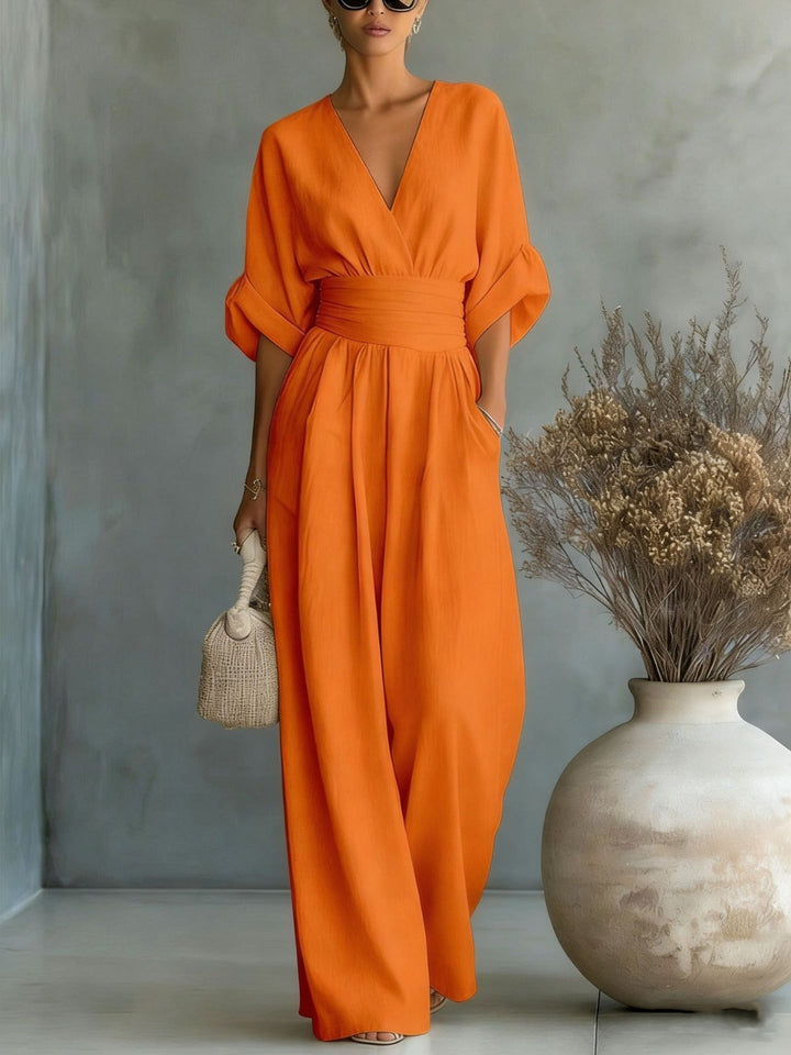 Moderner oranger Damen Jumpsuit mit schmeichelhafter Silhouette und seitlichen Taschen.