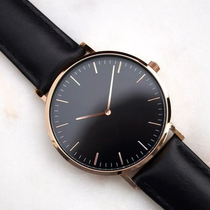 Luxus Herrenuhr mit schwarzem Zifferblatt, goldfarbenem Gehäuse und schwarzem Lederarmband.