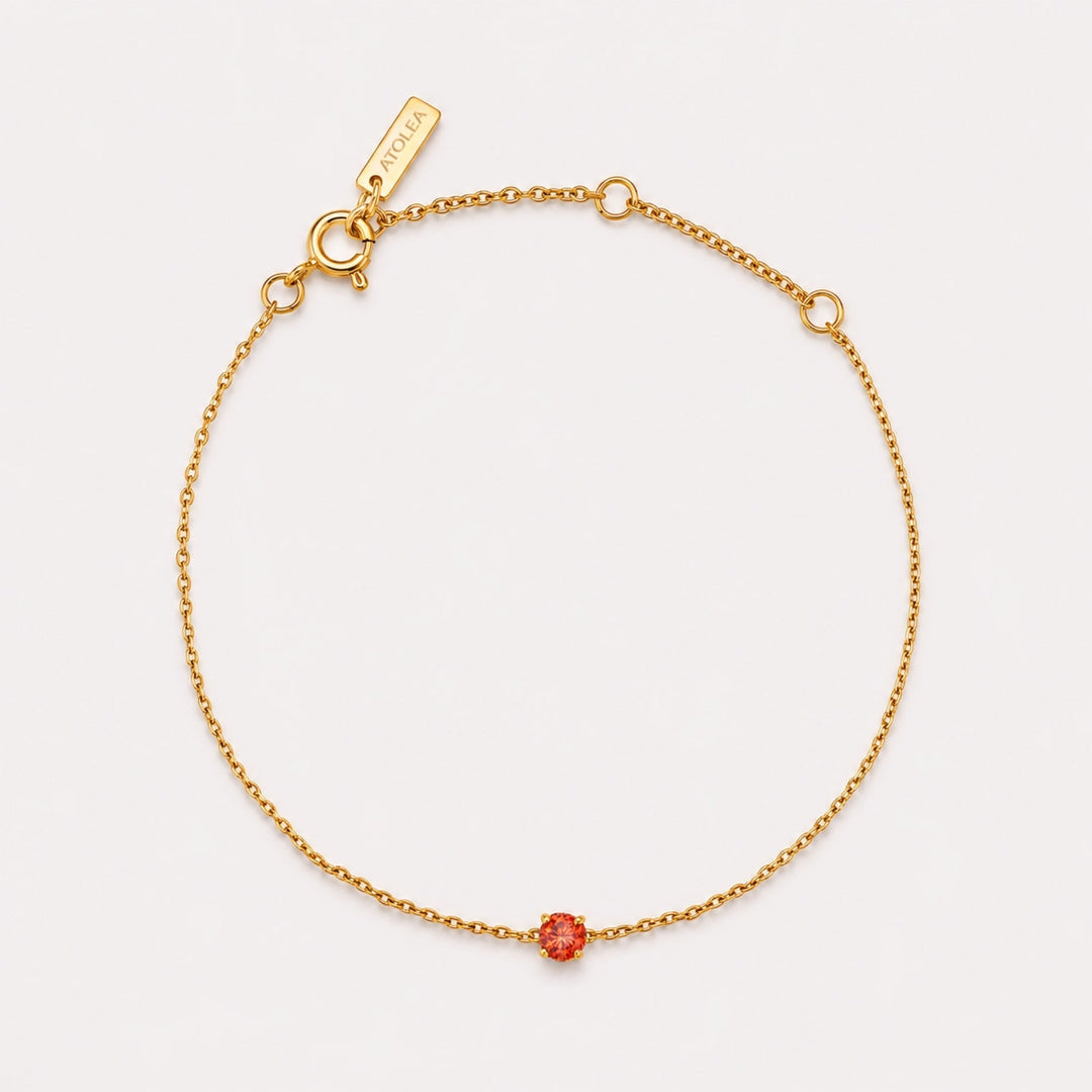 Goldenes Damen Armband mit rotem Geburtsstein und feiner Gliederkette auf hellem Hintergrund