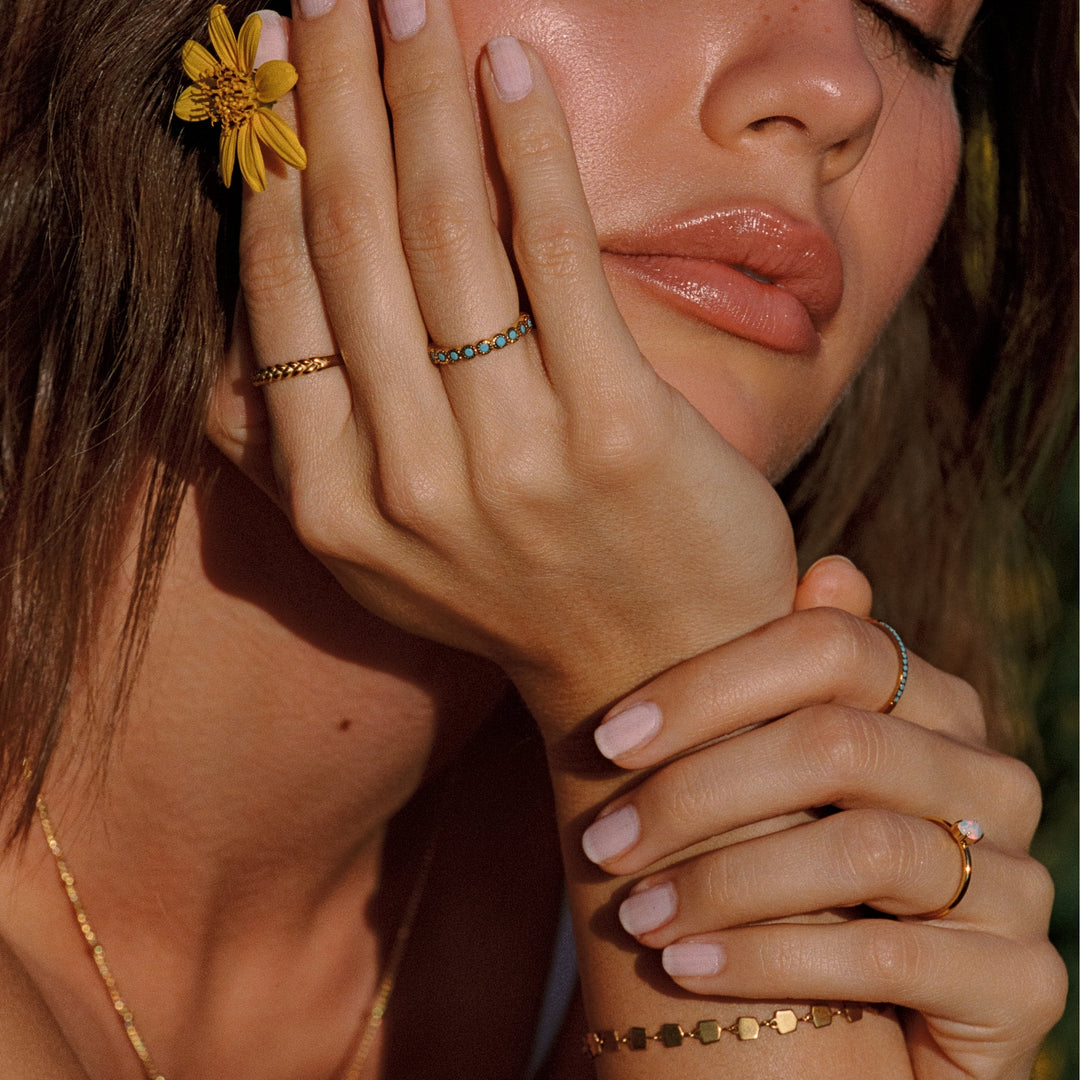 Minimalistischer Damenring in Gold mit türkisblauen Details am Finger