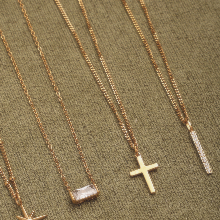 Modischer Damenschmuck in Gold mit glänzendem Bar Anhänger und Steinen