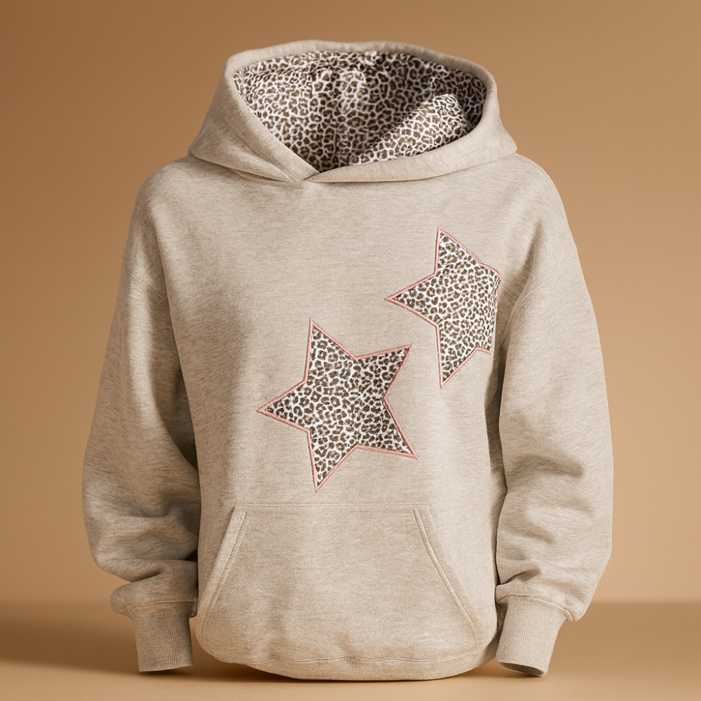 Nahaufnahme des trendigen Leoparden- & Sternenmusters auf weichem Damen Hoodie Stoff für Komfort.