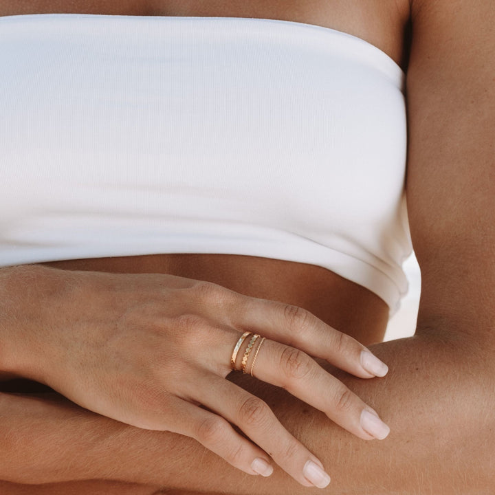Drei goldene Ringe als Set für Damen auf weißem Hintergrund