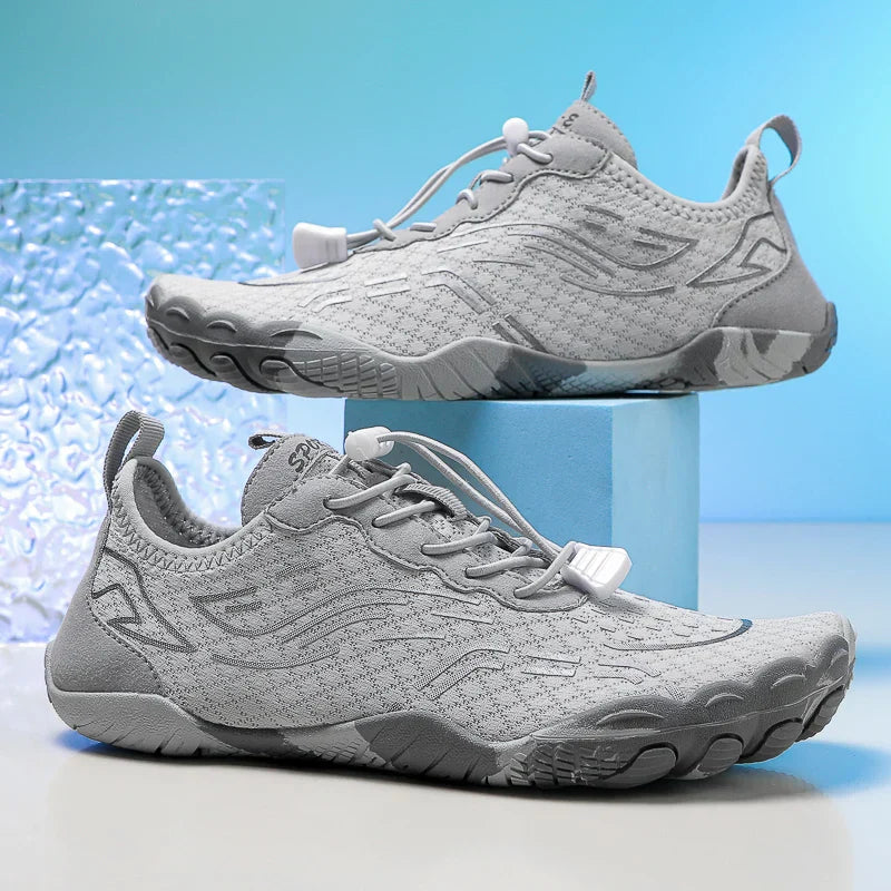 Person trägt flexible, schnelltrocknende Unisex Barfußschuhe am Strand. Perfekte rutschfeste Schwimmschuhe.