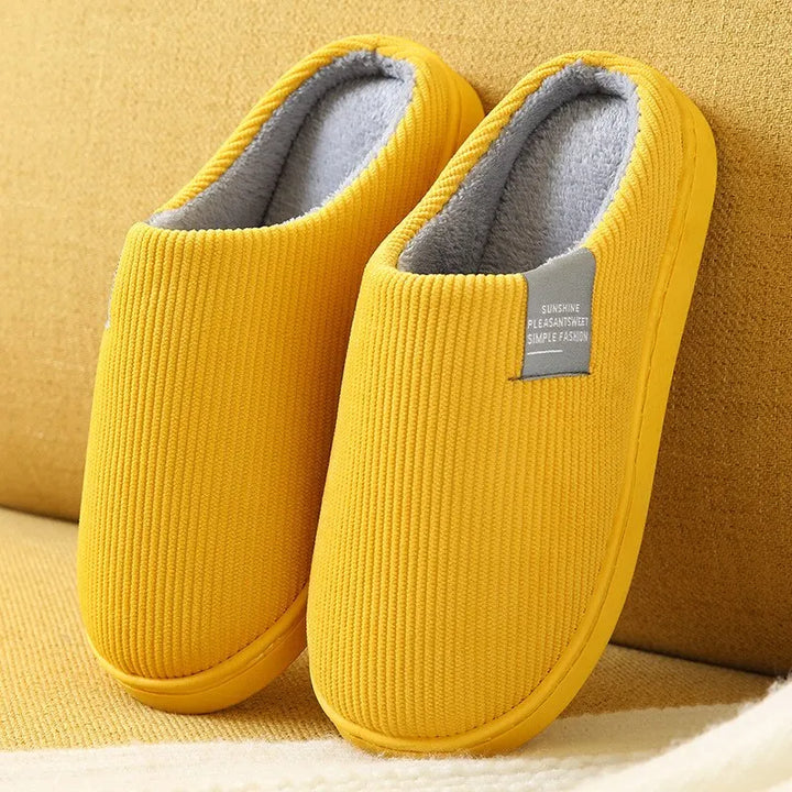 Einfache, stilvolle Unisex Hausschuhe auf dem Boden. Warme Pantoffeln für Damen & Herren, ideal für Zuhause.