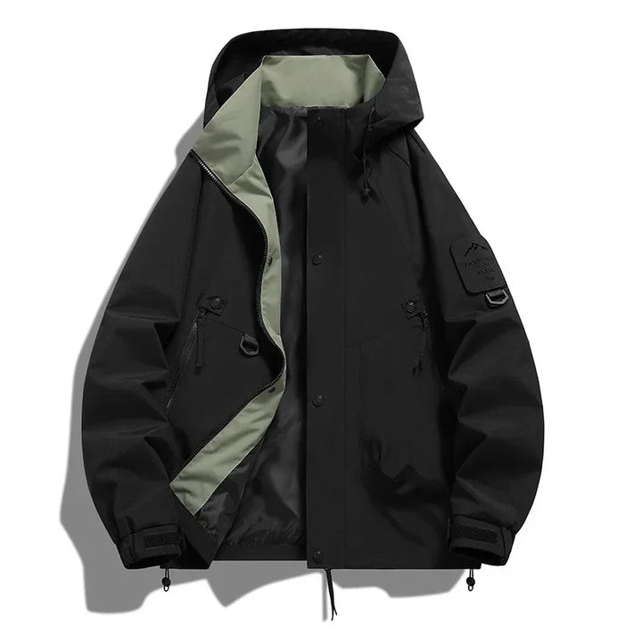 Aktiver Wintersportler in atmungsaktiver Unisex Kapuzen-Skijacke beim Skifahren im Schnee. Maximaler Schutz.
