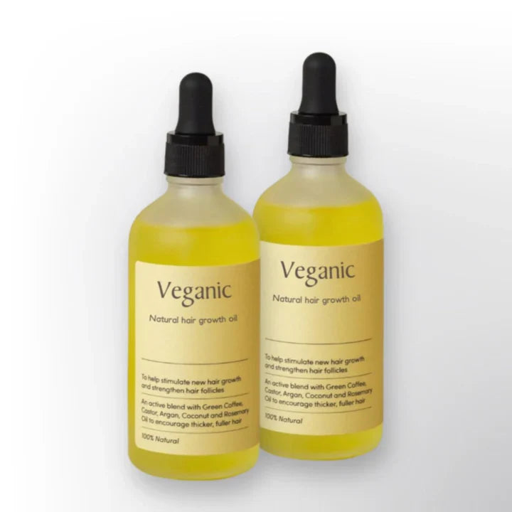 "Veganes Haarwuchsöl gegen Haarausfall, mit Grünkaffee und Arganöl, in einer eleganten Glasflasche vor weißem Hintergrund."