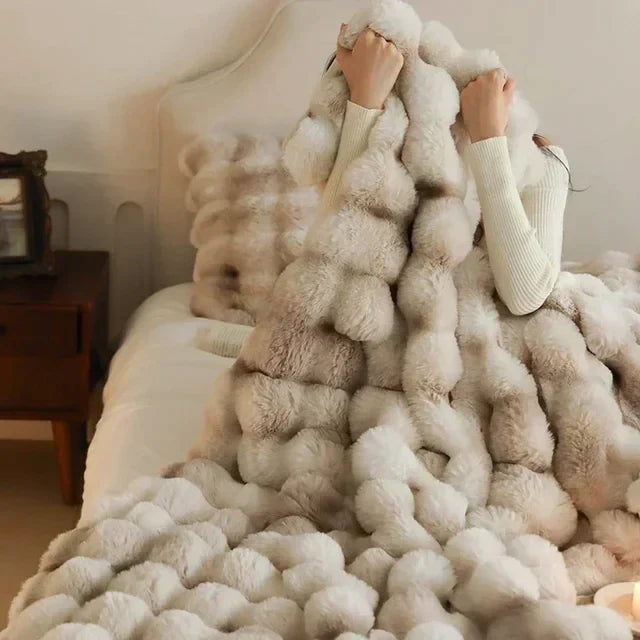 Weiche Kunstfelldecke in Beige, luxuriös und tragbar, perfekt für gemütliche Wärme zuhause oder unterwegs.