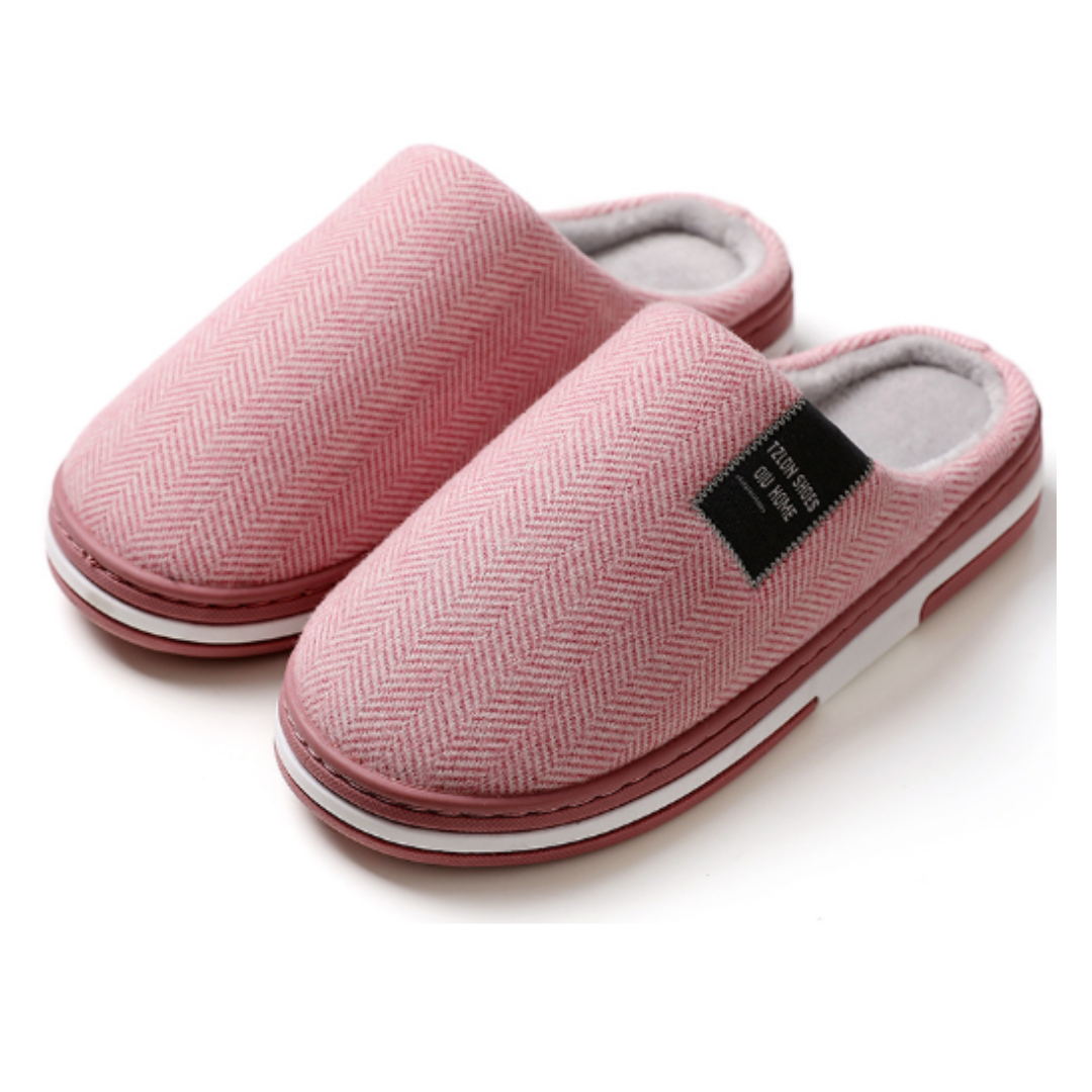 Ein Paar warme, bequeme Unisex Hausschuhe in neutraler Farbe, bereit für entspannte Momente und Komfort im Zuhause.