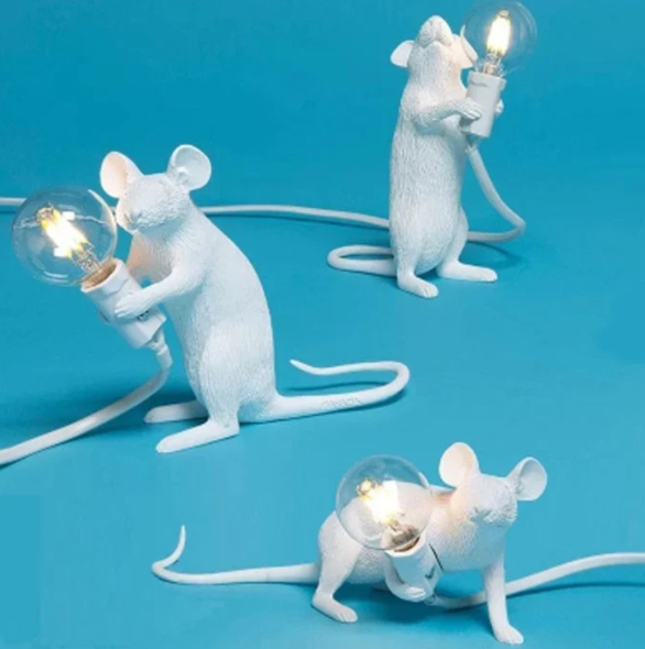 "Weiße Maus Tischleuchte in sitzender Position, strahlt warmes Licht, ideal für stilvolle Wohn- oder Schlafräume."