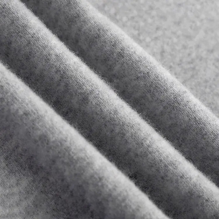 Detailaufnahme des feinen grauen Strickgewebes mit strukturierter Haptik